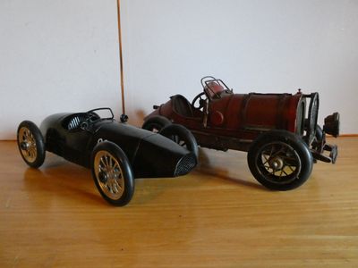 two toy cars that are sitting on a wooden floor