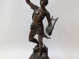 bronze statue of a man holding a bird on a wooden base
