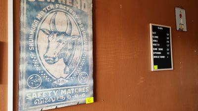 posters on the wall of a restaurant with a cow head on it