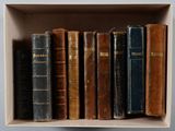 de nombreux livres anciens dans une boîte blanche posée sur une étagère