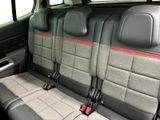 three seats in the back of a car that are grey and red