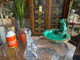 a green frog statue sitting on top of a green bowl