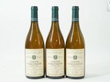 trois bouteilles de vin posées les unes à côté des autres sur une surface blanche