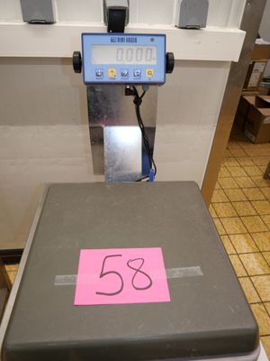 une balance sur laquelle est collé un autocollant rose