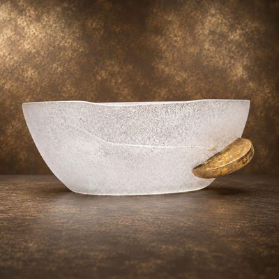 un saladier en verre avec une cuillère en bois posé sur une table