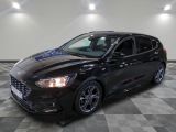 a black ford focus is parked in a room with a checkered floor