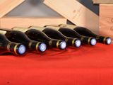several bottles of wine are lined up on a red table cloth
