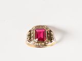 gros plan d'une bague en or avec une pierre rose