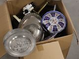 une boîte en carton remplie d'objets hétéroclites sur le sol