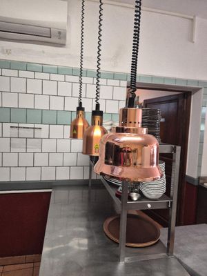 an image of a restaurant kitchen with a copper colored light fixture