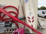 une planche de surf appuyée contre un mur, à côté d'une pile de bagages