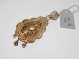 a close up of a gold pendant with a tag on it