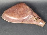 selle de moto en cuir marron posée sur une surface noire, avec un fond noir