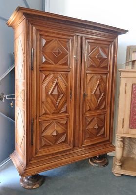 une armoire en bois dans une pièce, à côté d'un meuble en bois