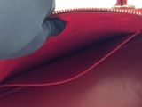 a red purse with a zipper on the inside of it