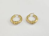 une paire de boucles d'oreilles en or sur fond blanc