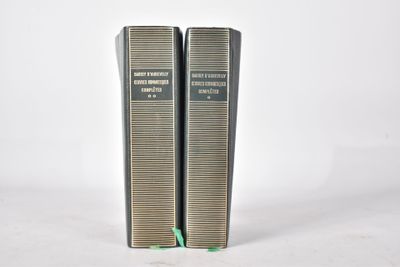 deux livres sont posés l'un sur l'autre sur une surface blanche