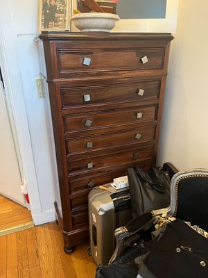 a chest of drawers with luggage on top of it