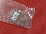 a small coin in a plastic bag on a red surface