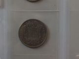 four different coins in a clear box on a table