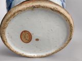 a blue and white vase sitting on a white surface