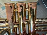 a close up of a brass trumpet with rust on it