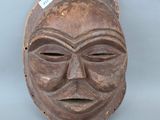 gros plan d'un masque en bois sur une surface blanche