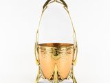 a gold metal basket with handles and handles on a white background