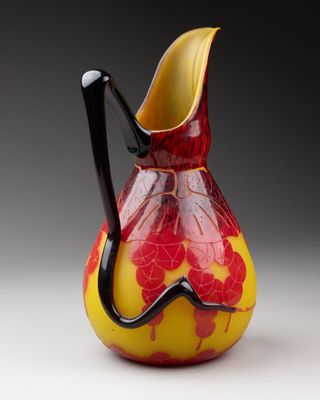 un vase rouge et jaune muni d'une anse noire