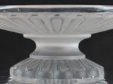 a clear glass bowl on a table with a black background