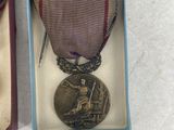 an old medal in a box with a ribbon on top of it
