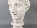a close up of a statue of a man ' s head on a pedestal