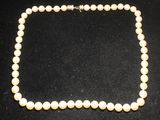 gros plan d'un collier de perles sur une surface noire