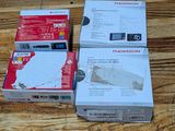 three boxes of electronic equipment sitting on top of a wooden table