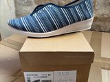 blue and white striped shoes on a cardboard box on top of a cardboard box