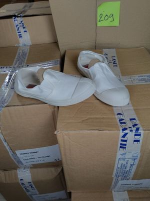 une paire de chaussures blanches posée sur une pile de cartons