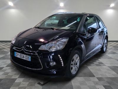 la voiture noire est garée sur un sol en damier dans le garage
