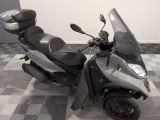 un scooter garé sur un sol à damier