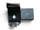 a box with a watch inside of it on a white surface