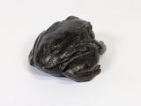 a small frog that is sitting on a white surface