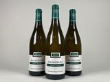 trois bouteilles de vin posées sur une table blanche