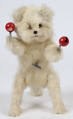 un ours en peluche blanc tenant deux balles rouges dans ses pattes