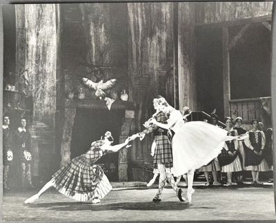 photographie en noir et blanc d'un couple de danseurs se produisant devant un groupe de personnes