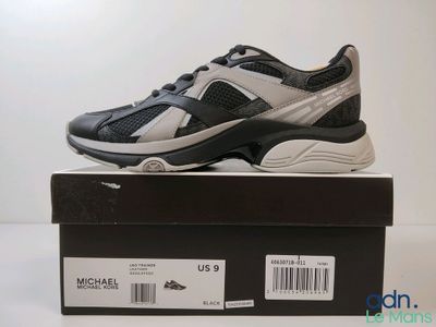 une chaussure noire et blanche posée sur une boîte avec une étiquette de prix