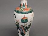 a vase with a painting on it sitting on a table