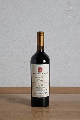 a bottle of red wine sitting on a wooden table