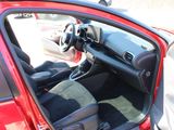 a red car with its door open sitting in a parking lot
