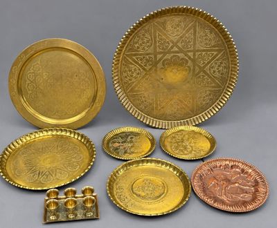 several different types of brass plates and trays on a gray surface