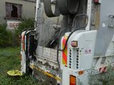 a garbage truck that is parked in the grass