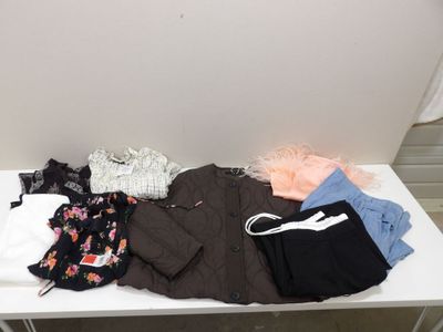 une table blanche sur laquelle sont posés un tas de vêtements
